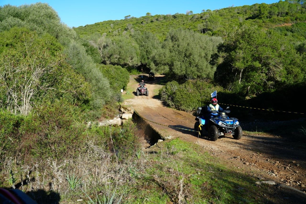 Quad apripista con bandiera lungo il sentiero nel verde
