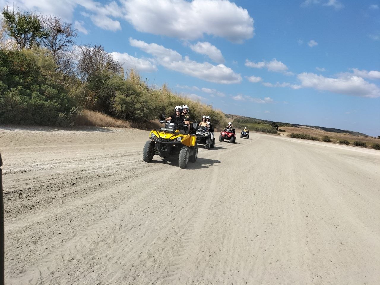 Colonna di quad su ampio sterrato sabbioso